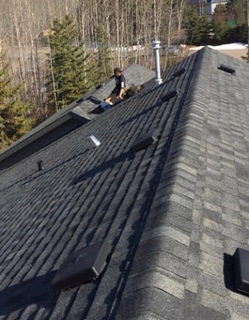 A man repairing a roof on a sunny day.