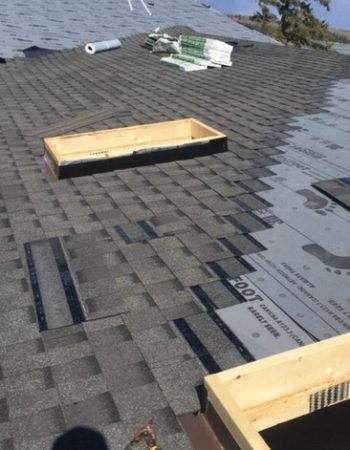 A roof with shingles and a roofing repair in progress.