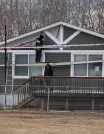 A man repairing the roof of a house.